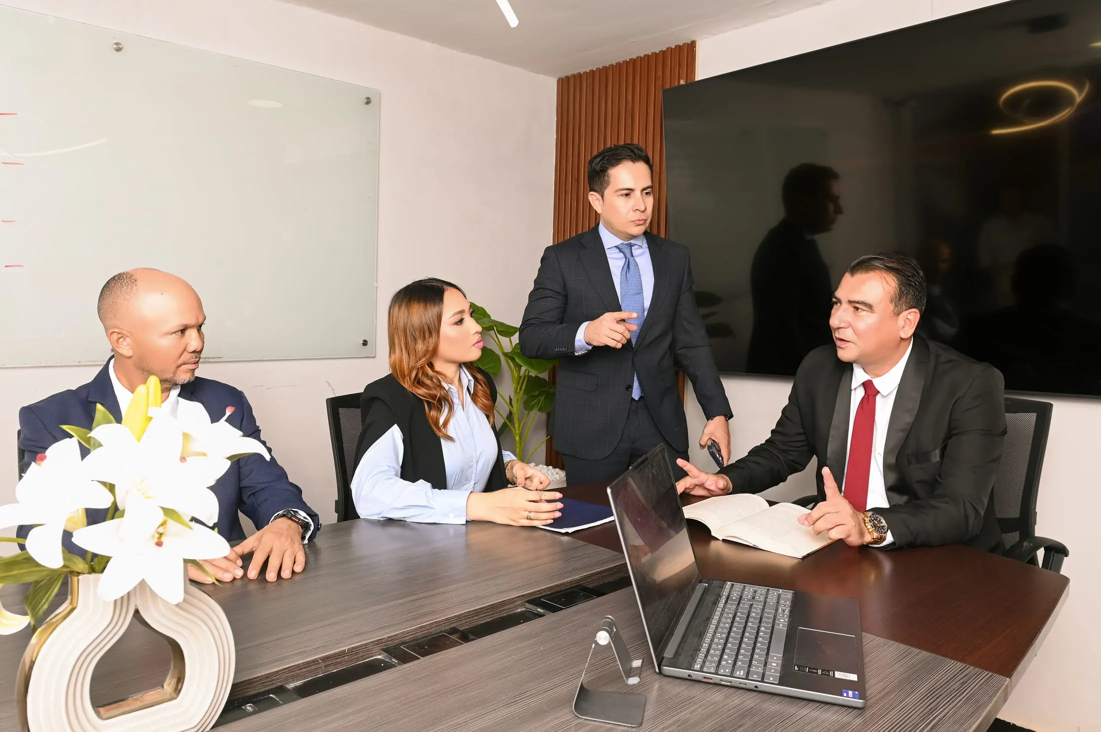 Profesionales de Law Expert Group conversando alrededor de la mesa de la sala de juntas